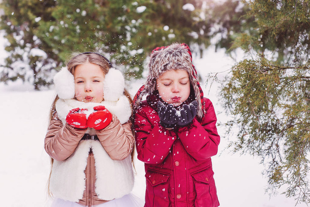Los niños soplando nieve, niños y diversión en el invierno
 - Foto, Imagen
