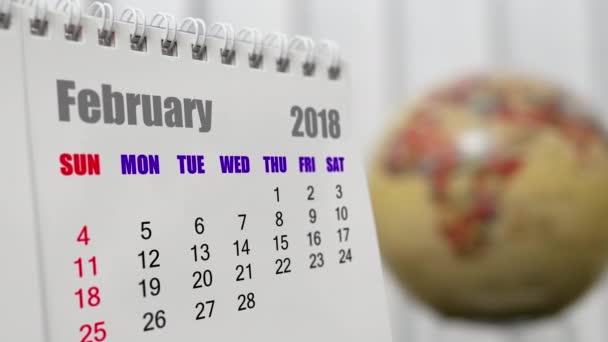 Movimiento de febrero 2018 calendario con globo de tierra borrosa girando fondo
 - Imágenes, Vídeo