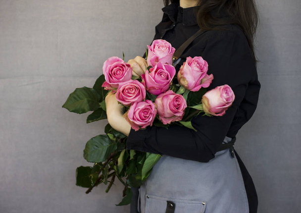 Jeune femme fleuriste hilding grand bouquet de roses
 - Photo, image