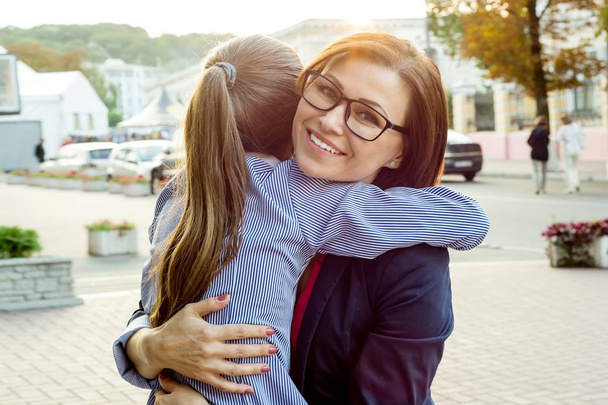 Beautiful mom and her daughter are hugging and smiling. - Zdjęcie, obraz