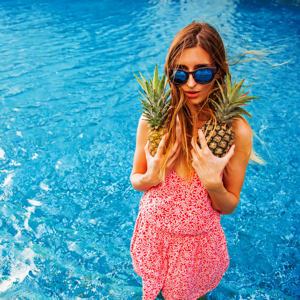 young woman holding fresh ripe pineapples  - Фото, изображение