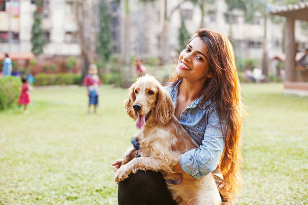 Beautiful indian girl with her cocker spaniel dog - Foto, afbeelding