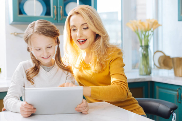 Exuberant mother and daughter using a tablet - Foto, imagen