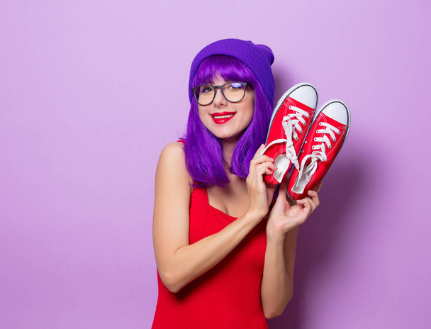 Πορτρέτο των νέων στυλ hipster κορίτσι με μπλε μαλλιά και κόκκινα γαλότσα σε μοβ φόντο - Φωτογραφία, εικόνα