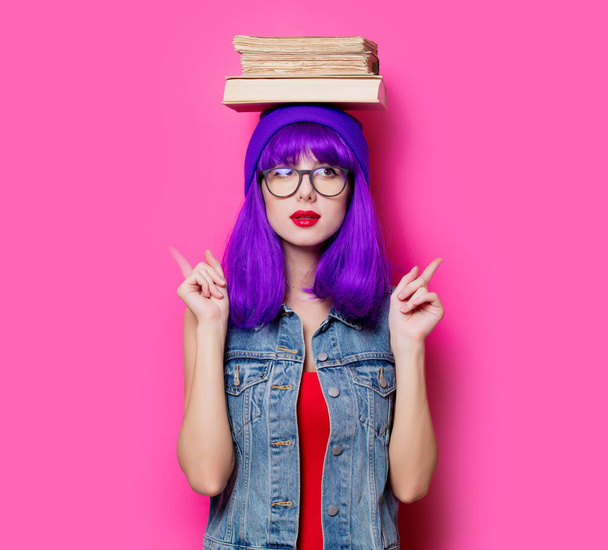 Portret van jonge stijl hipster meisje met bruin haar en boeken op roze achtergrond - Foto, afbeelding