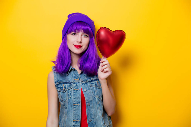 Retrato de chica hipster de estilo joven con pelo morado y globo en forma de corazón sobre fondo amarillo. Día de San Valentín
  - Foto, Imagen
