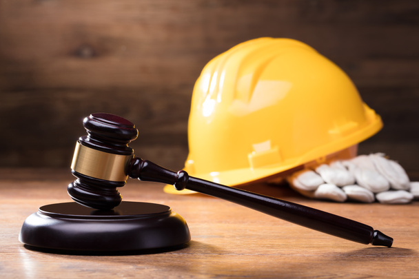 Judge Gavel In Front Of Yellow Safety Helmet On The Wooden Table - Foto, immagini