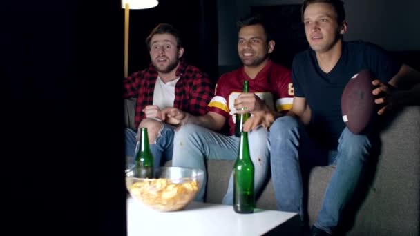 Excited men watching football on television - Video