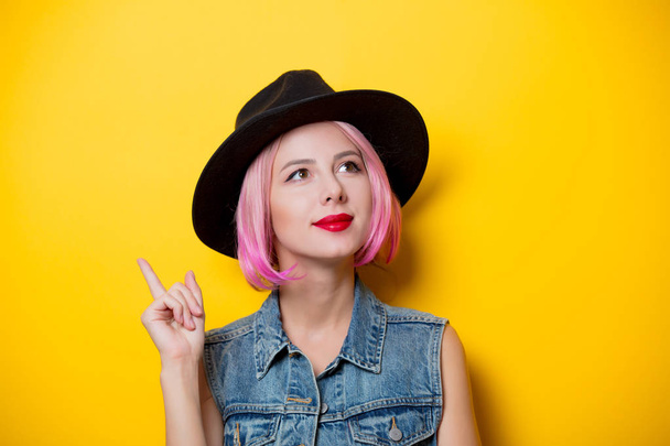 Portrait de jeune fille hipster de style avec une coiffure rose sur fond jaune
 - Photo, image