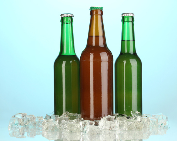 butelek piwa w lodzie na niebieskim tle - Zdjęcie, obraz