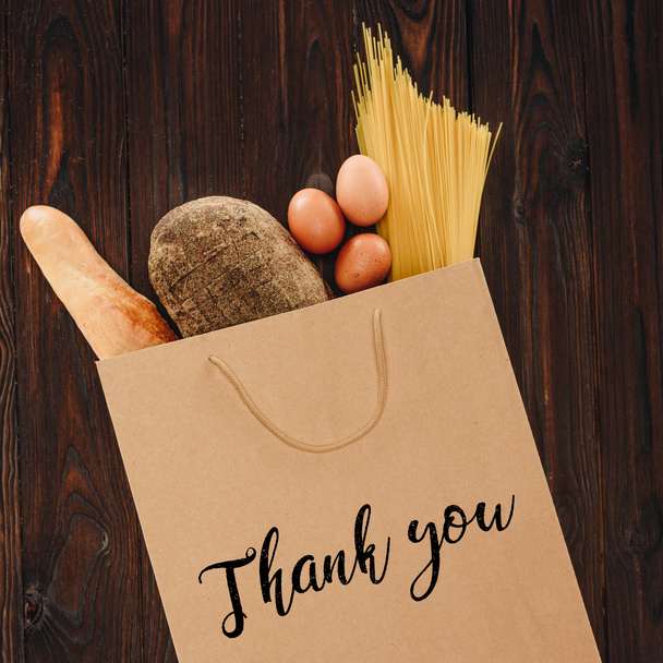 vista superior de pão, massas e ovos em saco de papel com palavras obrigado, conceito de supermercado
 - Foto, Imagem