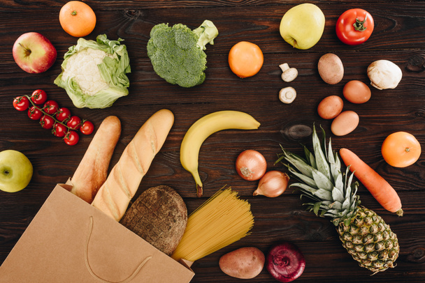 Widok z góry warzyw i owoców z chlebem w torba na zakupy na drewnianym stole, koncepcja spożywczy - Zdjęcie, obraz