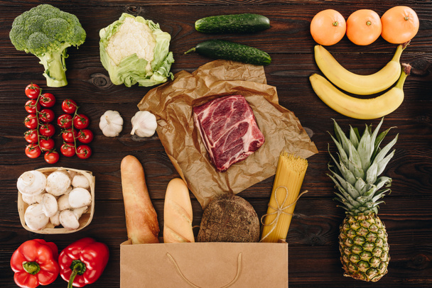 top view of raw meat with vegetables and fruits on wooden table, grocery concept  - Foto, Imagen