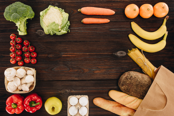 pohled shora ze zeleniny a ovoce, chléb a těstoviny v papírové tašce, koncept s potravinami - Fotografie, Obrázek