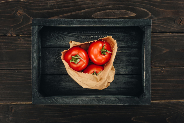κάτοψη του κόκκινες ντομάτες σε χαρτί τσάντα για ψώνια - Φωτογραφία, εικόνα