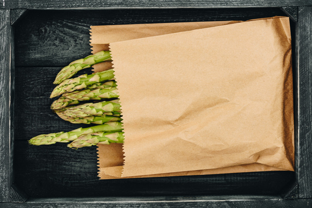 bovenaanzicht van asperge in papieren zak winkelen - Foto, afbeelding