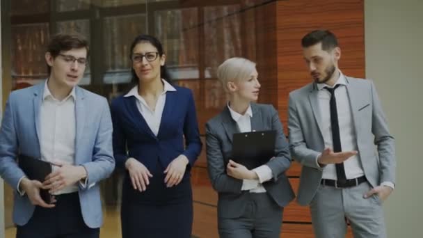 Group of young business people talking and walking in office lobby - Footage, Video