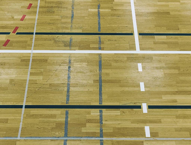 Pintado piso de madera del pabellón deportivo con líneas de marcado de colores. Gimnasio escolar
 - Foto, imagen