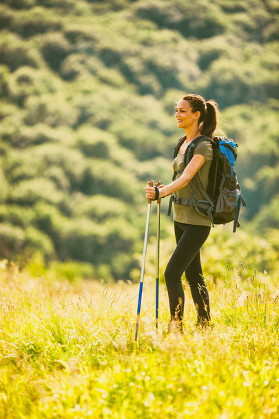 Jonge vrouw is wandelen in Berg en genieten van de natuur.  - Foto, afbeelding