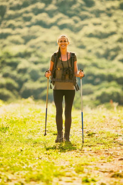 Jonge vrouw is wandelen in Berg en genieten van de natuur.  - Foto, afbeelding
