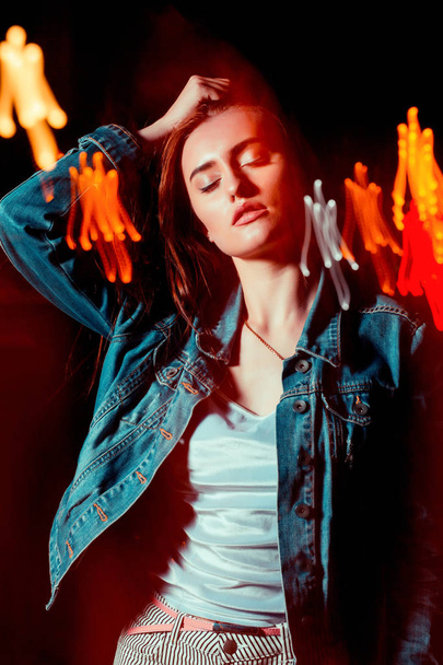 Modieuze brunette vrouw poseren in gemengde licht techniek op th - Foto, afbeelding