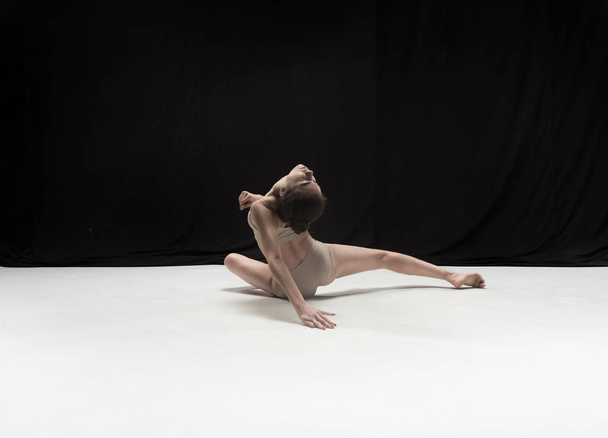 Young teen dancer on white floor background. - Foto, afbeelding