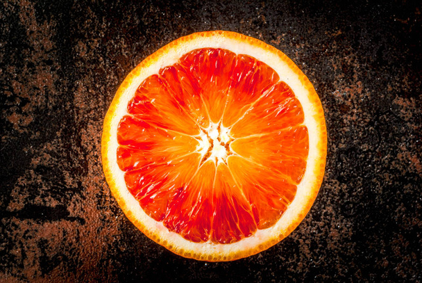 Свіжі сирі апельсини крові, половина, з м'ятою, на темному іржавому фоні
 - Фото, зображення