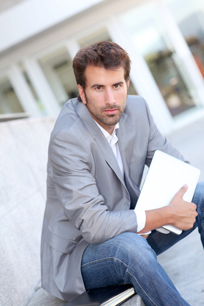 Relaxed businessman sitting outside with tablet - Фото, изображение