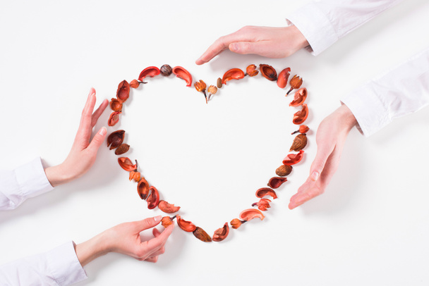 обрізане зображення пари, що робить серце з сухофруктів на день валентинки на білому
 - Фото, зображення