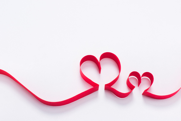 two red hearts from ribbon on white, valentines day concept - Photo, Image