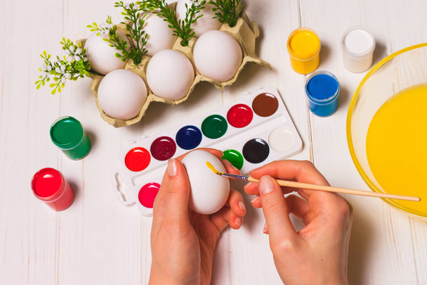 Two hands paint eggs for Easter - Foto, imagen