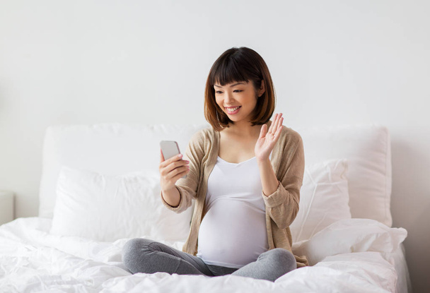 pregnant woman taking selfie by smartphone at home - Foto, Bild