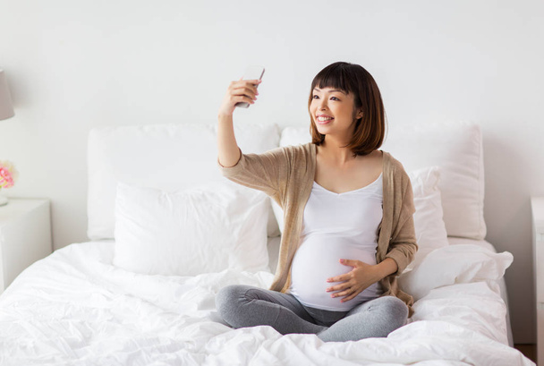 pregnant woman taking selfie by smartphone at home - Φωτογραφία, εικόνα