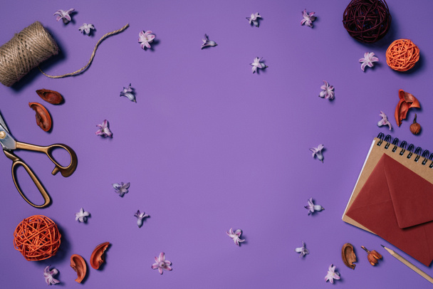 плоский лежал с организованными цветами, конверт, ножницы и веревки для украшения изолированы на фиолетовый
  - Фото, изображение