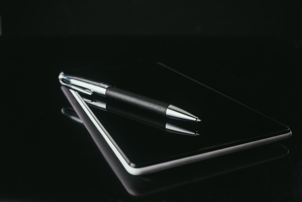 крупным планом цифровой планшет с ручкой на черной поверхности
 - Фото, изображение