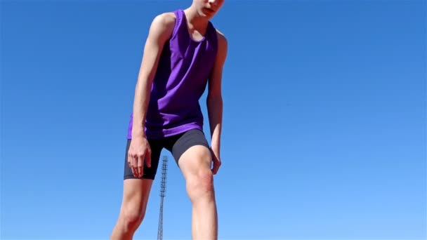 Alacsony, szög, kilátás a pályán futó fiú tinédzser a kezdőcsapatban, 4k - Felvétel, videó