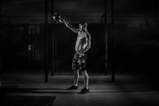 Izmos férfi sportoló húz fogyás az edzőteremben fekete-fehér-szűrő - Fotó, kép