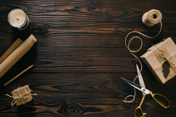 flat lay with wrapped presents, rope and scissors on wooden surface - Photo, Image