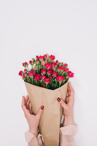 częściowy widok kobiecych rąk i bukiet róż w paper craft na szarym tle - Zdjęcie, obraz