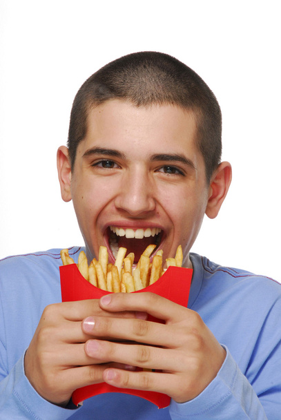 Giovane ragazzo mangiare patatine fritte e ketchup
. - Foto, immagini