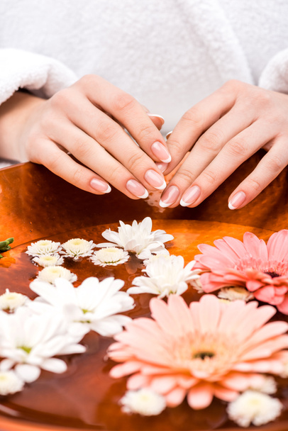vue recadrée de la femme faisant procédure spa avec des fleurs, concept de soins des ongles
 - Photo, image