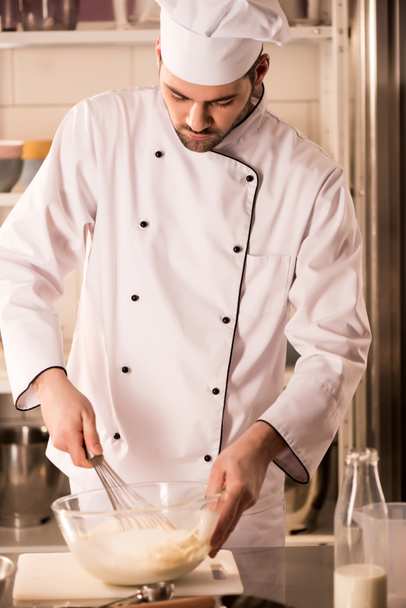 confeiteiro focado em chapéu de chef fazendo massa na cozinha do restaurante
 - Foto, Imagem