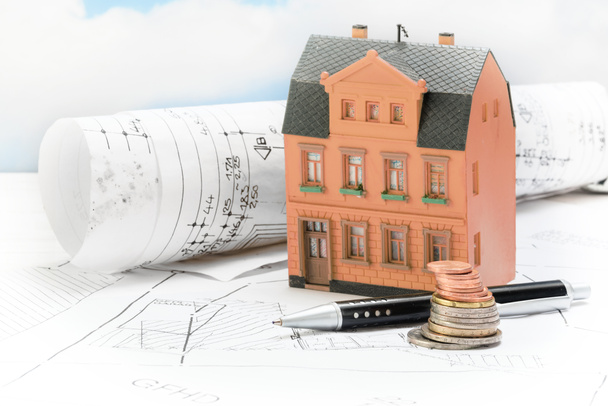 Investition in Altbausanierung, Musterhaus mit Bauplänen, Münzen und Stift, Immobilienkonzept mit Kopierraum - Foto, Bild