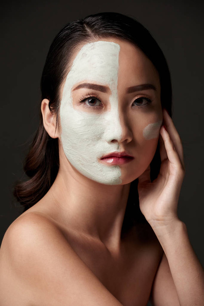 Pretty woman with rejuvenating clay mask on her face - Photo, Image