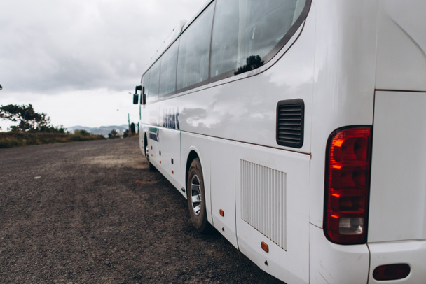 view of white bus back with rainy clouds in sky - Photo, Image