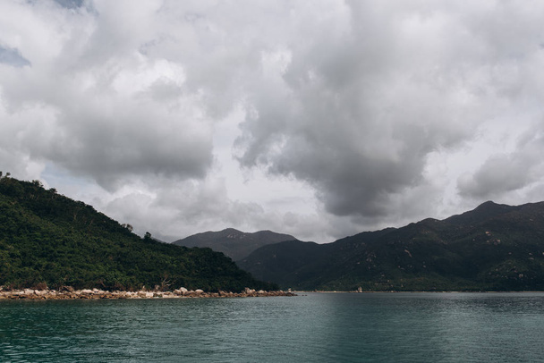 Vista cercana de la isla con el mar y el cielo gris en el fondo
  - Foto, imagen