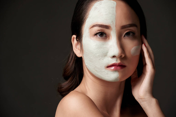 Китайская девушка в белой глиняной маске на лице смотрит в камеру
 - Фото, изображение