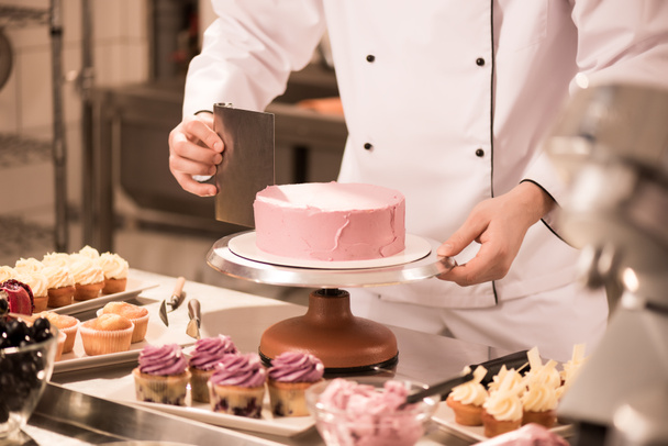 περικοπεί shot του ζαχαροπλάστη καθιστώντας κέικ σε κουζίνα εστιατορίου - Φωτογραφία, εικόνα