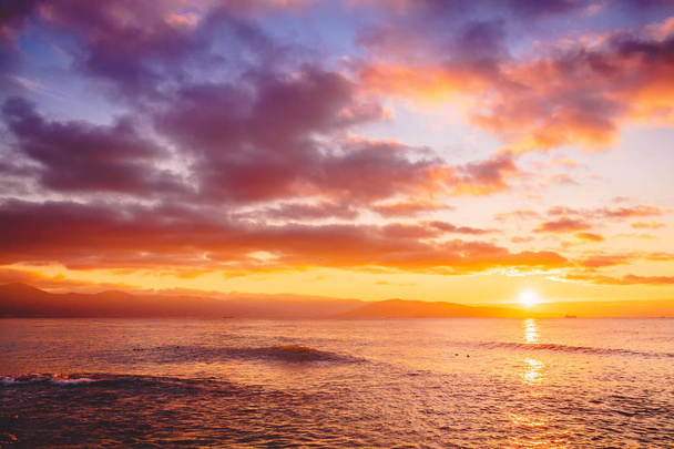 Яркий закат или рассвет в океане. Пейзаж с теплыми цветами заката или восхода солнца
 - Фото, изображение