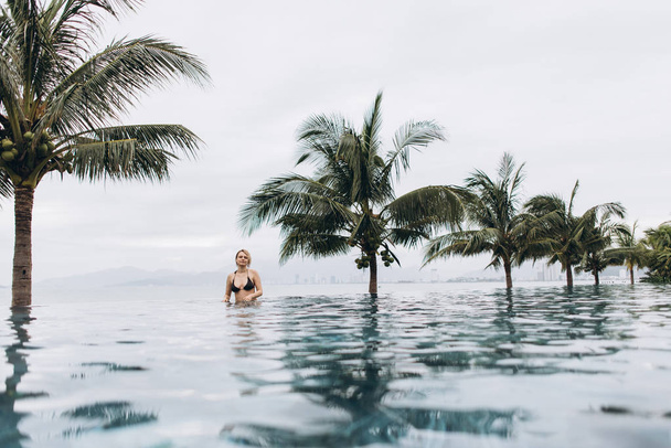 Nézd a nő visel bikini pihentető medencében kívül - Fotó, kép